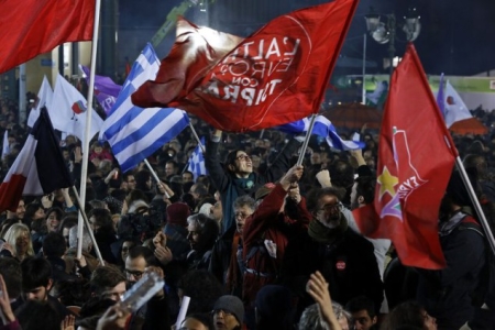 Supporters of radical leftist Syriza party chant slogans and wave Greek national and other flags after winning elections in Athens, January 25, 2015. Greek Prime Minister Antonis Samaras has called Tsipras to congratulate him on winning Sunday's snap election, a spokesman for Syriza and an official of the ruling conservative party said. REUTERS/Alkis Konstantinidis (GREECE - Tags: POLITICS ELECTIONS)