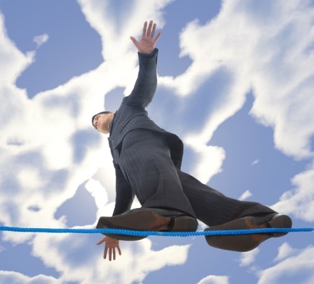 Young businessman walking on line in the air. Holding balance. Low angle view